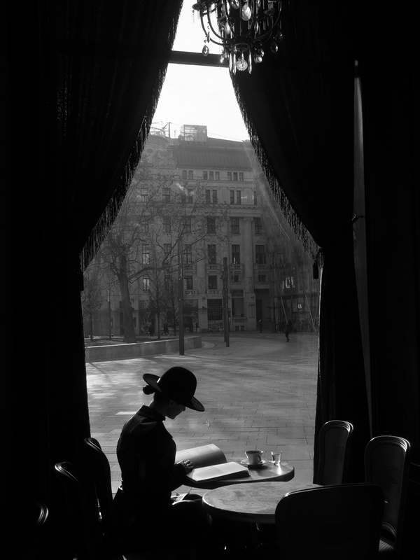 Woman in Window of Budapest Cafe Reading a Book Woman in Window of Budapest Cafe Reading a Book